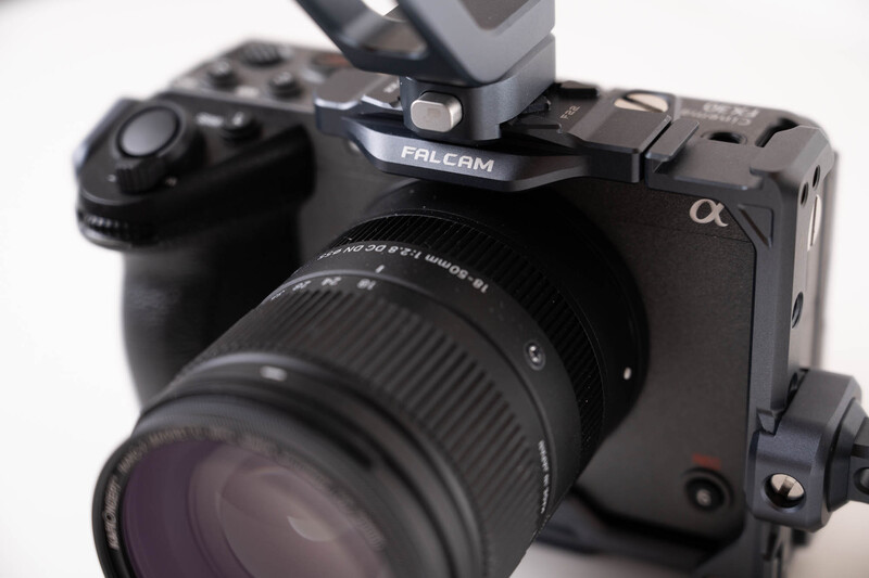 Sony Alpha mirrorless camera with Falcam top plate and standard zoom lens mounted against white background.