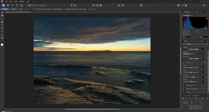Coastal seascape at sunset with warm golden light reflecting on calm water and rocky foreground.