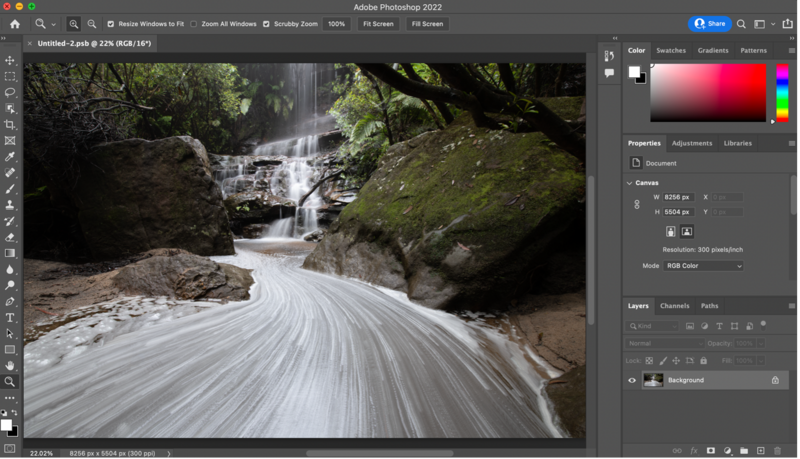 Long exposure waterfall photograph showing silky water flowing over rocks in a forested stream.