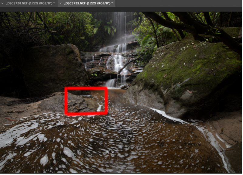 Cascading waterfall flowing through a moss-covered rocky forest stream with a red rectangle highlighting composition consideration.