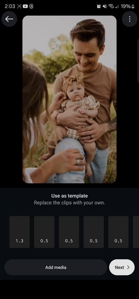 Father holding infant while mother touches the baby's arm during outdoor family portrait session.
