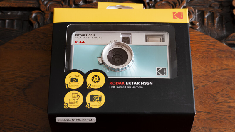 Kodak Ektar H35N half-frame film camera in retail packaging on wooden surface.