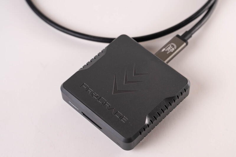 Black external hard drive with chevron pattern and attached USB cable on white surface.