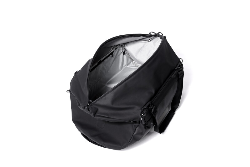 Black camera bag with open main compartment revealing gray interior padding and organizational space.