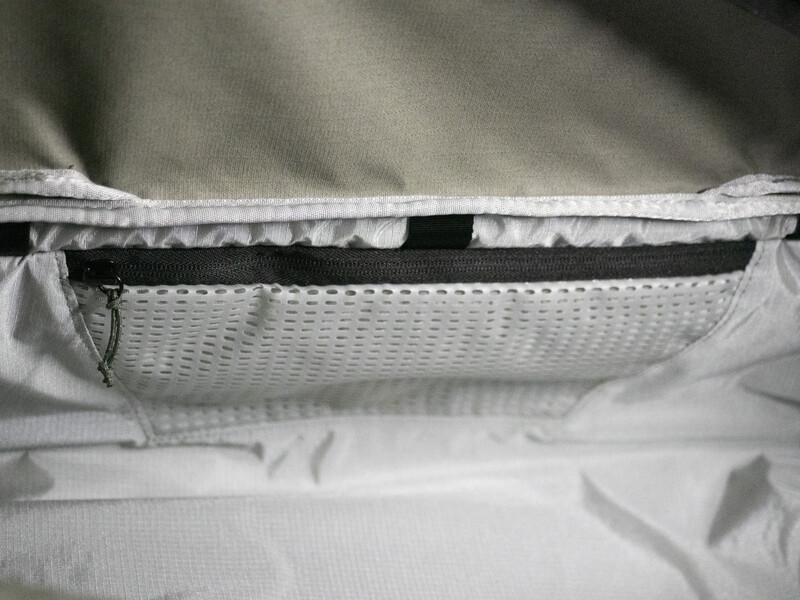 Close-up view of a camera bag's interior pocket with mesh ventilation panel and zipper detail.