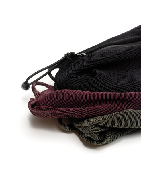 Stack of three zippered pouches in black, burgundy, and olive green with black hardware.