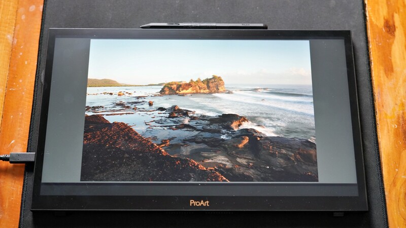 Coastal landscape with rocky outcrop and breaking waves displayed on a ProArt monitor.
