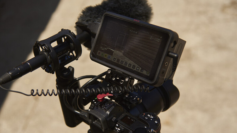 Camera rig with external monitor and shotgun microphone mounted on top.