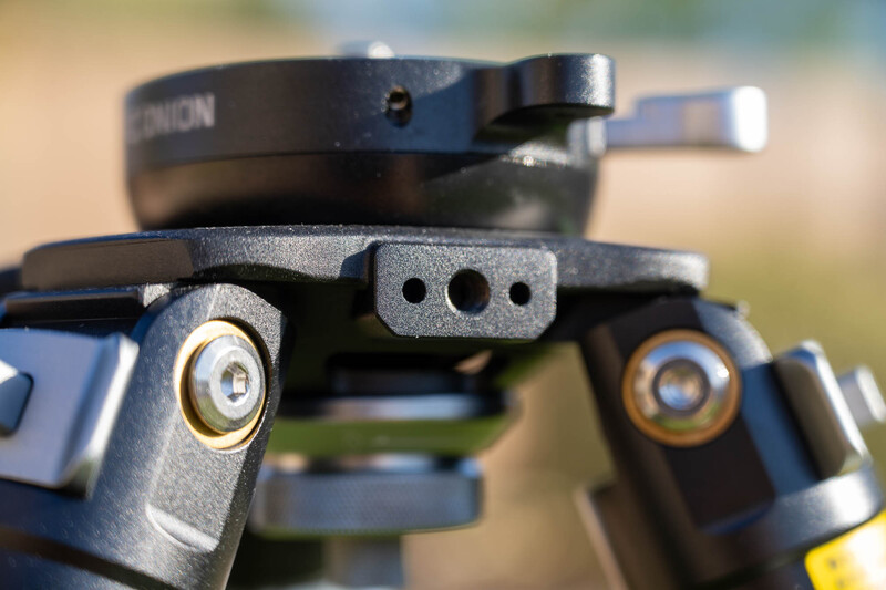 Close-up of a tripod head showing brass adjustment knobs and mounting plate details.