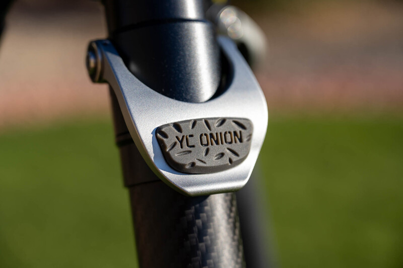 Close-up of a white bicycle stem cap with 'XC ONION' text engraved on it.
