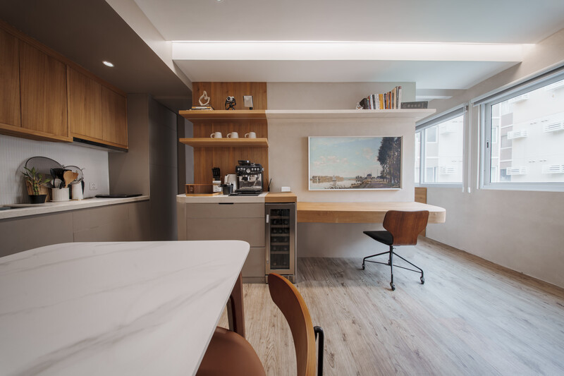 Modern apartment interior with warm wood cabinetry, white countertop, and natural light from large windows.