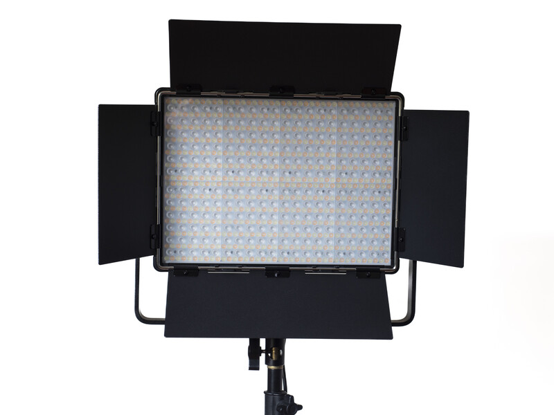 Large LED panel light with adjustable barn doors and diffusion panel mounted on stand.