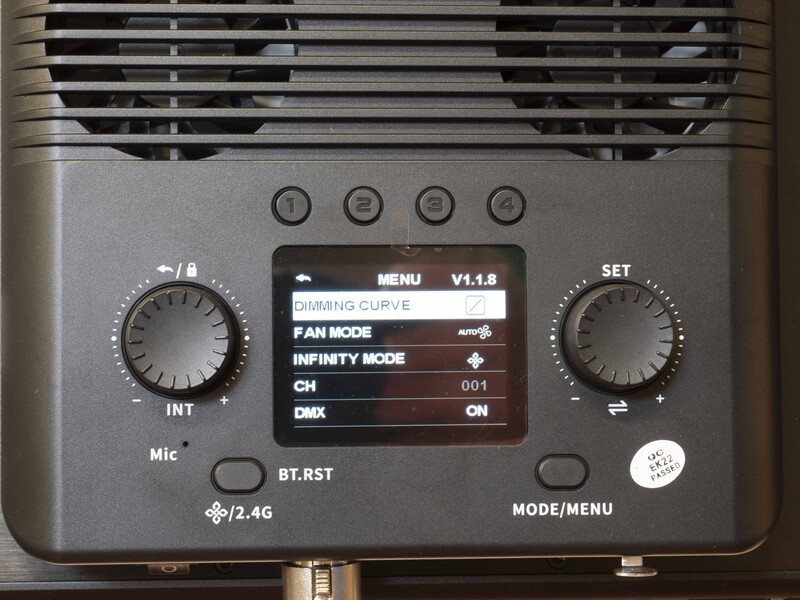 Close-up of audio interface control panel with knobs, display menu, and microphone input.