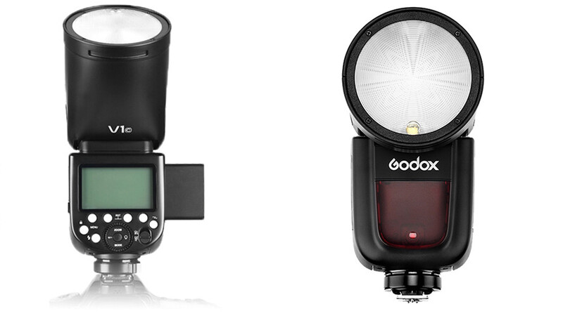 Two external camera flashes side by side: a Vis flash with LCD screen and controls on the left, and a Godox flash with dome diffuser on the right.