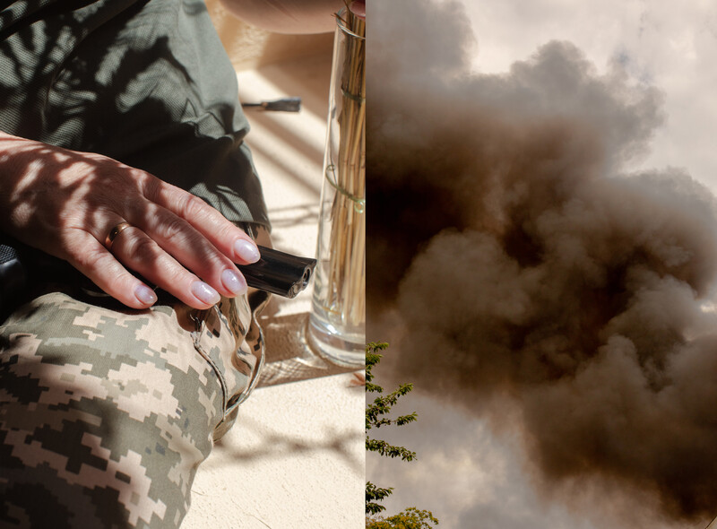 Soldier's hands holding rifle with explosion and smoke visible in background landscape.