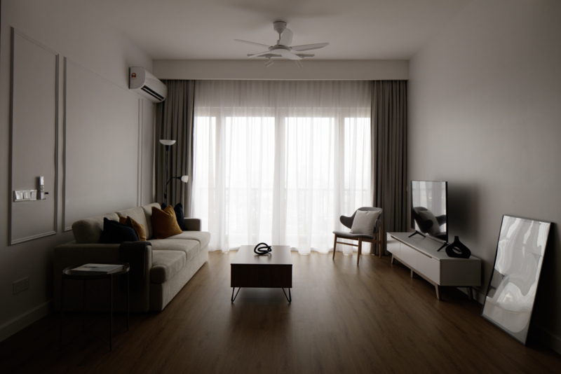 Modern living room with dark furniture, large windows with sheer and dark curtains, and minimalist decor.