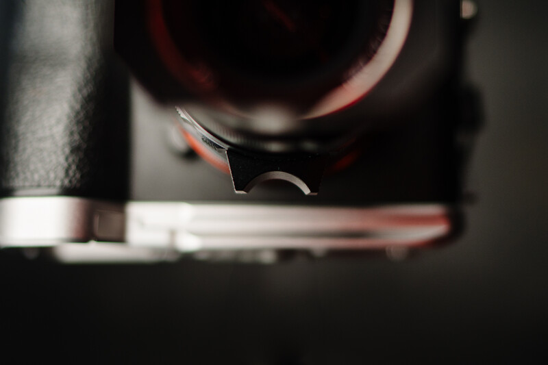 Close-up of a 3D printer nozzle extruding molten filament onto a print bed during active printing.