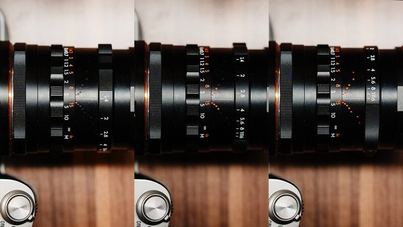 Three vintage rangefinder camera lenses displayed side-by-side showing focus and aperture rings with depth markings.