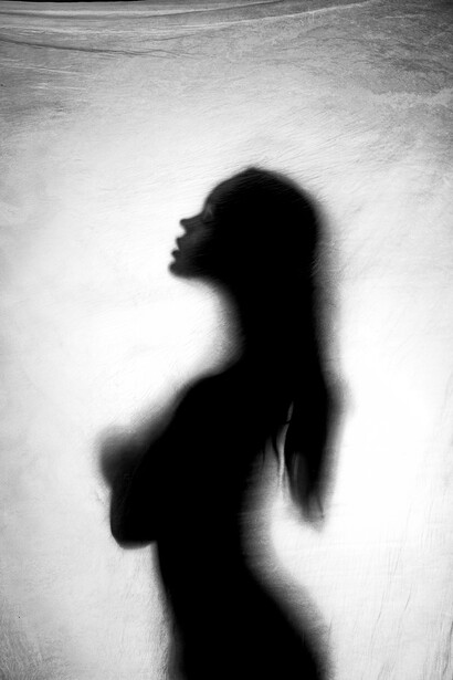 Silhouette of a woman in profile against a textured light background.