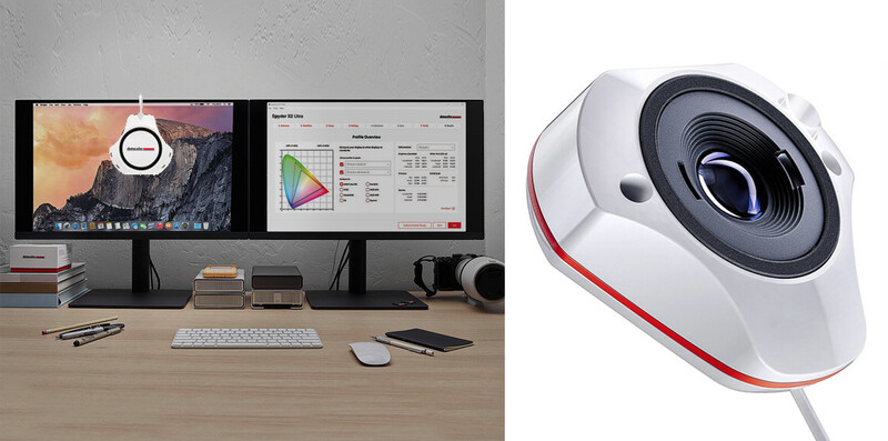 Professional color-grading workstation with dual monitors displaying image and color data alongside a white and red webcam.