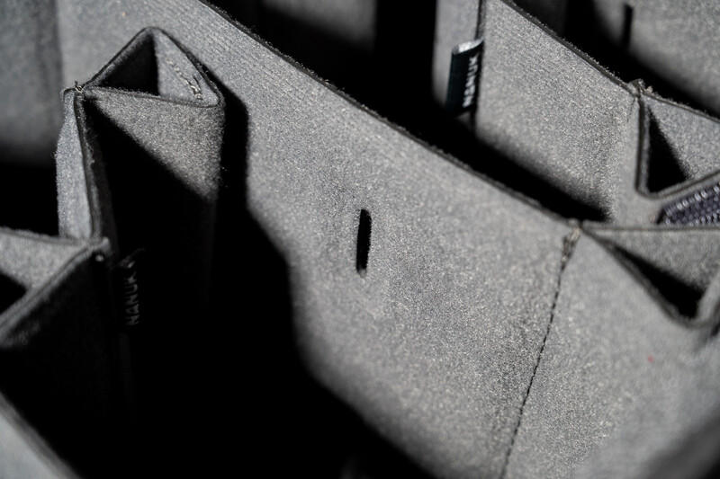 Close-up of gray fabric dividers in a camera bag insert with deep shadows and textured material.