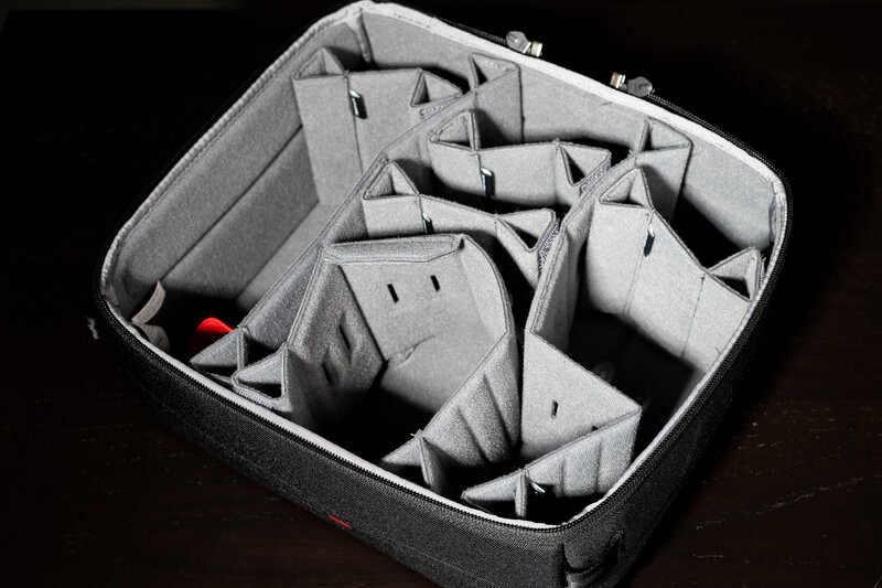 Interior view of a camera bag organizer with multiple gray padded dividers creating compartments for equipment.