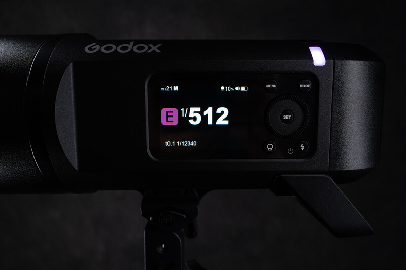 Godox flash unit displaying settings on its LCD screen in low light conditions.