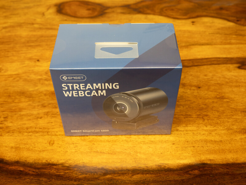 Streaming webcam in packaging box on wooden surface.