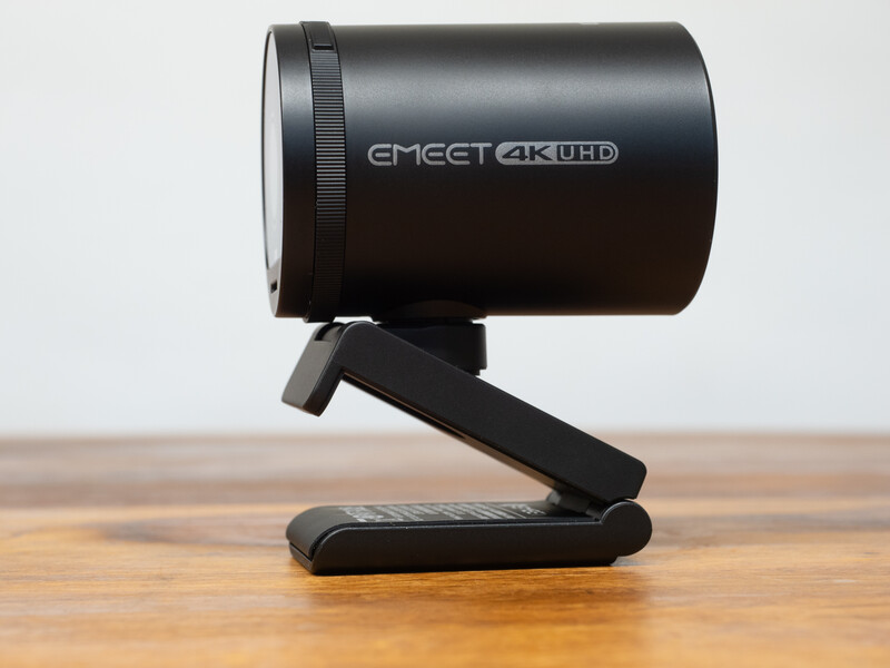 EMEET 4K UHD webcam mounted on a black articulating stand on a wooden surface.