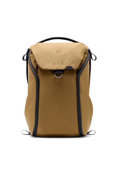 Tan canvas camera backpack with black straps and front compartment flap against white background.
