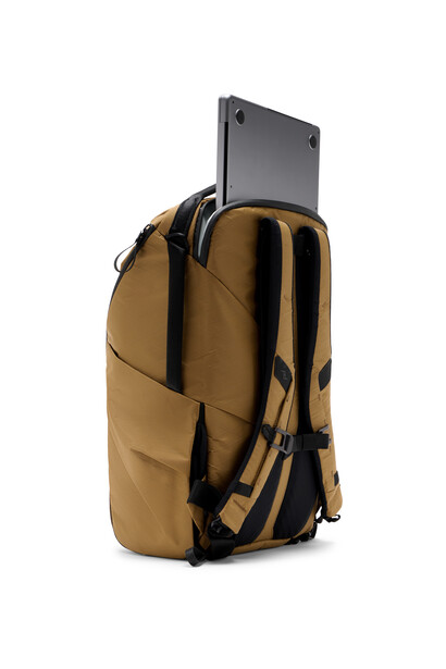 Tan canvas backpack with black straps and a laptop compartment visible at the top.