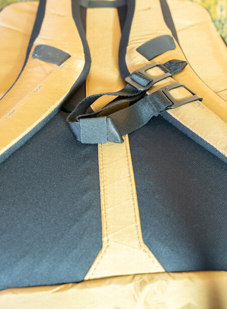 Camera bag interior view showing yellow and black fabric compartments with black straps and buckles.