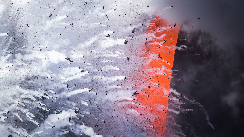 Orange geometric shape disintegrating into particles against a stormy gray and white background.