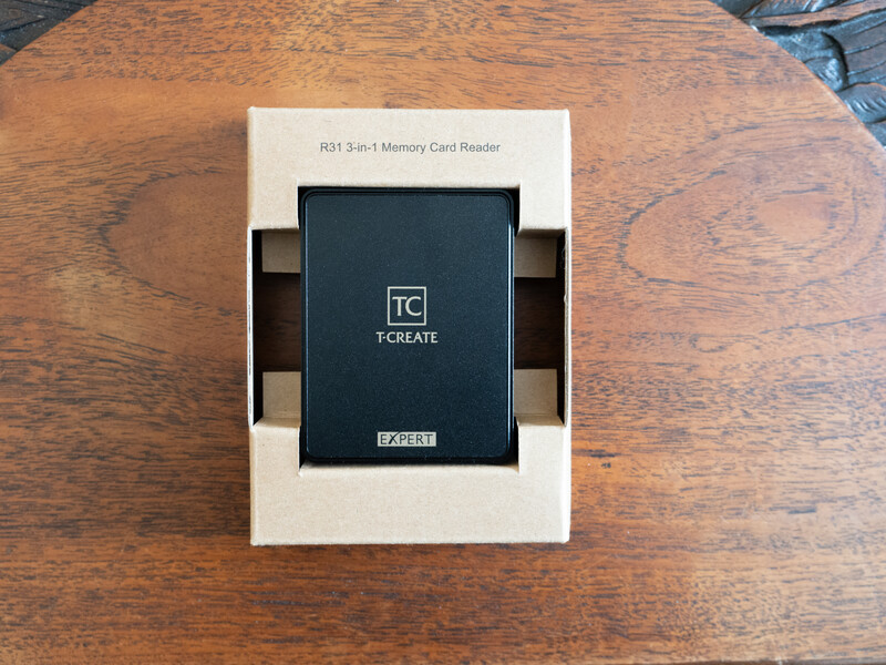 Tscreate 3-in-1 memory card reader in white retail packaging on wooden surface.