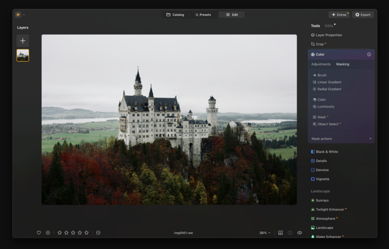 Neuschwanstein Castle perched on a forested hilltop with autumn foliage and distant mountains.