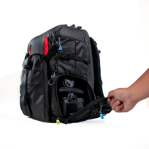 Black camera backpack with red accents and multiple compartments, displayed with front pocket open.