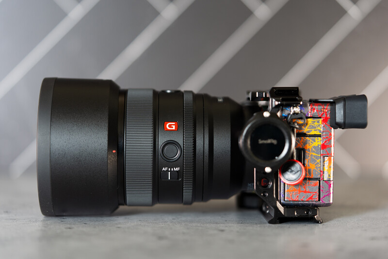 Sony mirrorless camera body mounted with a large telephoto lens and colorful gaffer tape on the grip.