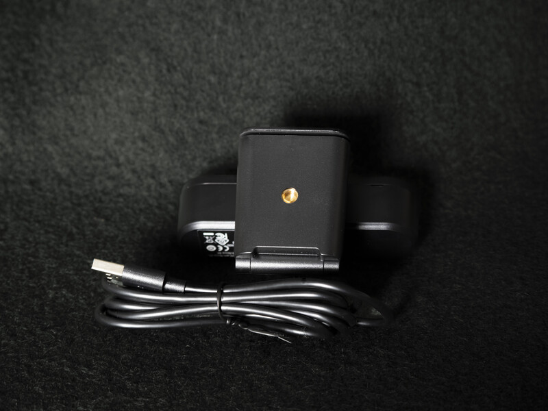 Black power adapter with coiled cable on dark textured surface.