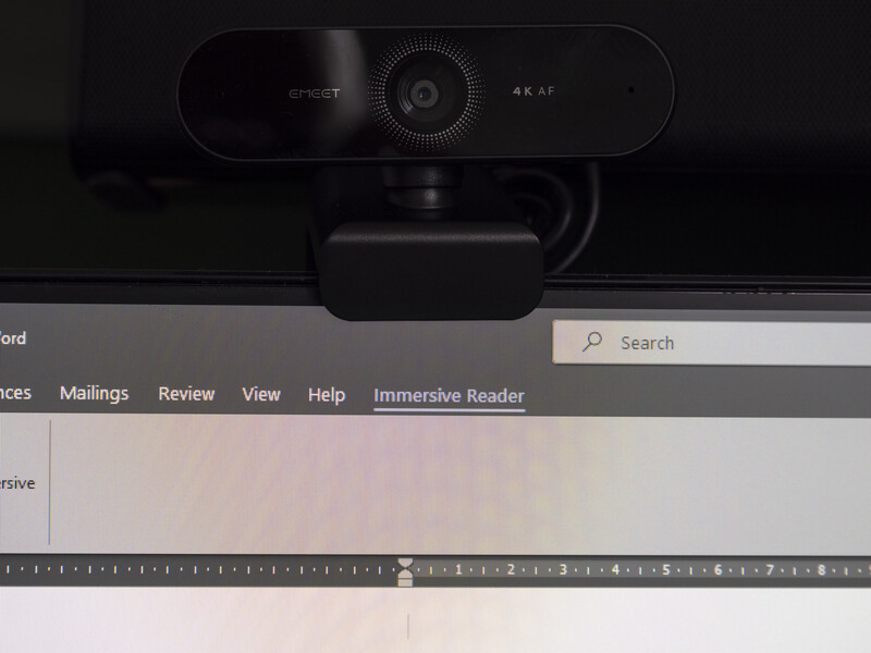 4K webcam mounted on top of a monitor displaying a word processing application.