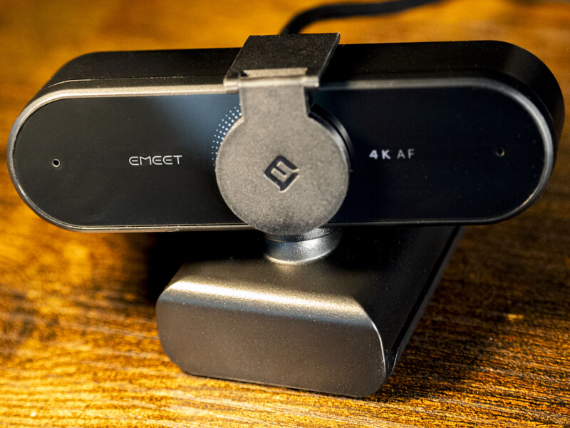 EMEET 4K AF webcam with gray privacy shutter mounted on wooden surface.