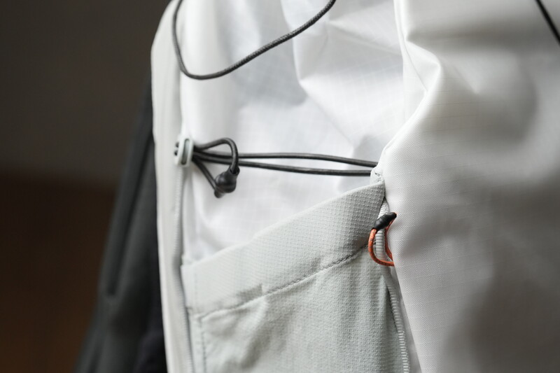 Close-up of a white garment with a lavalier microphone clipped to the fabric and its cable running upward.