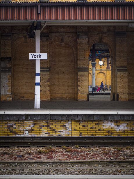 York railway station platform with arched brick ceiling and yellow tile detailing.