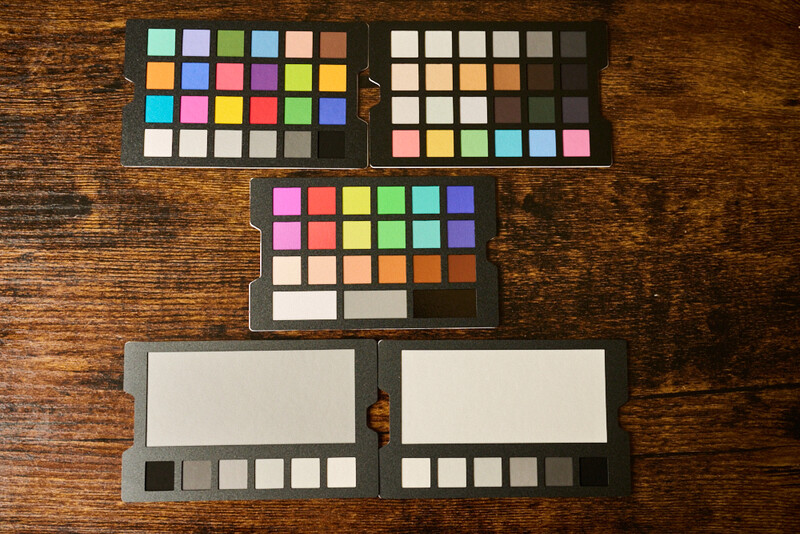 Four color reference cards with gray frames and color swatches arranged on a wooden surface.