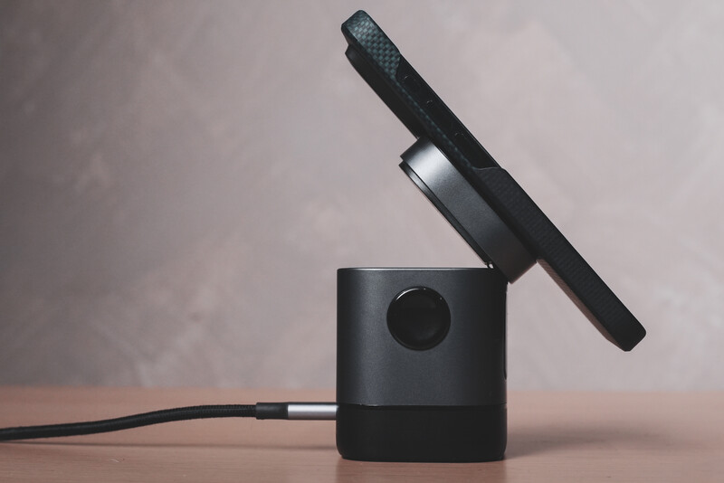 Black cylindrical audio interface with microphone mounted on top and coiled cable attached.