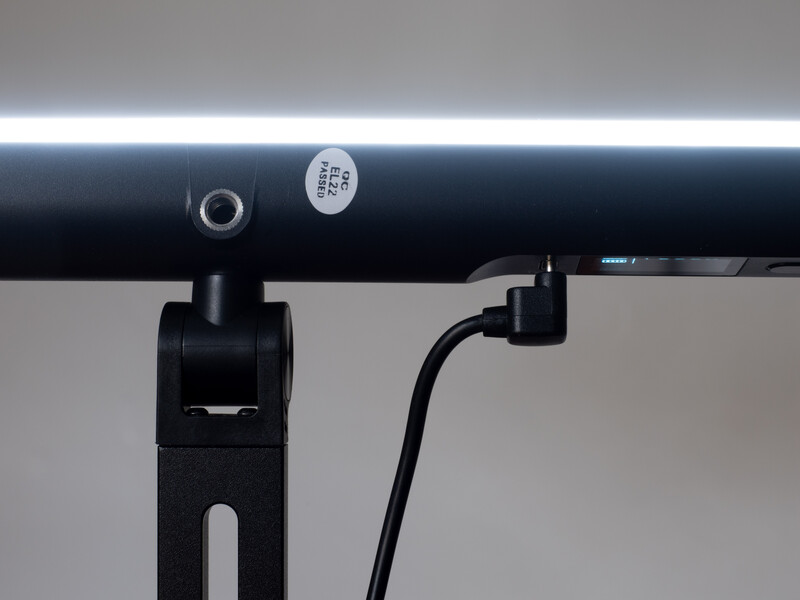 Close-up of a black mounting bracket and cable connection on a studio light rail system.