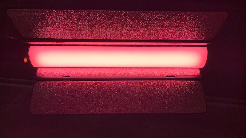 Glowing pink neon tube mounted horizontally on a dark textured ceiling.