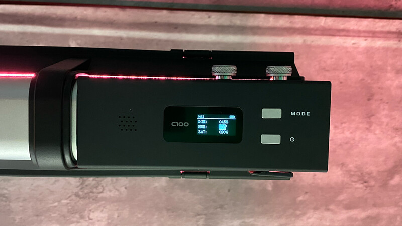 Close-up of a camera control panel with illuminated LCD display showing settings and mode buttons.