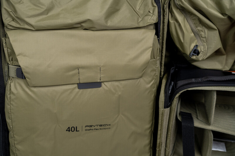 Close-up of a 40-liter camera backpack with tan exterior and multiple compartments visible.