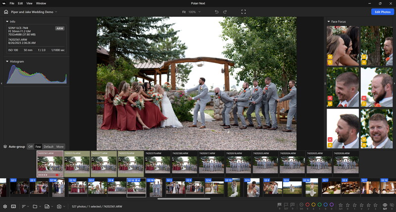 Wedding ceremony under a wooden arbor with guests in formal attire gathered on a gravel area surrounded by trees.