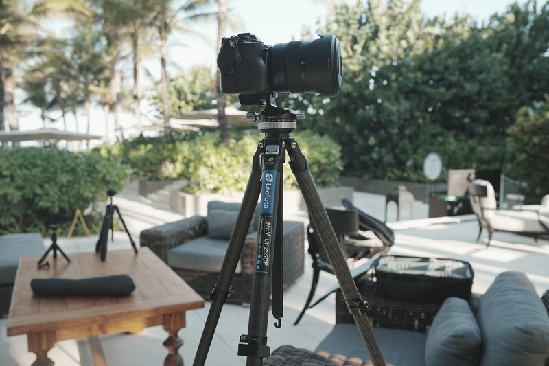 Professional camera mounted on tripod in outdoor rooftop setting with natural daylight.